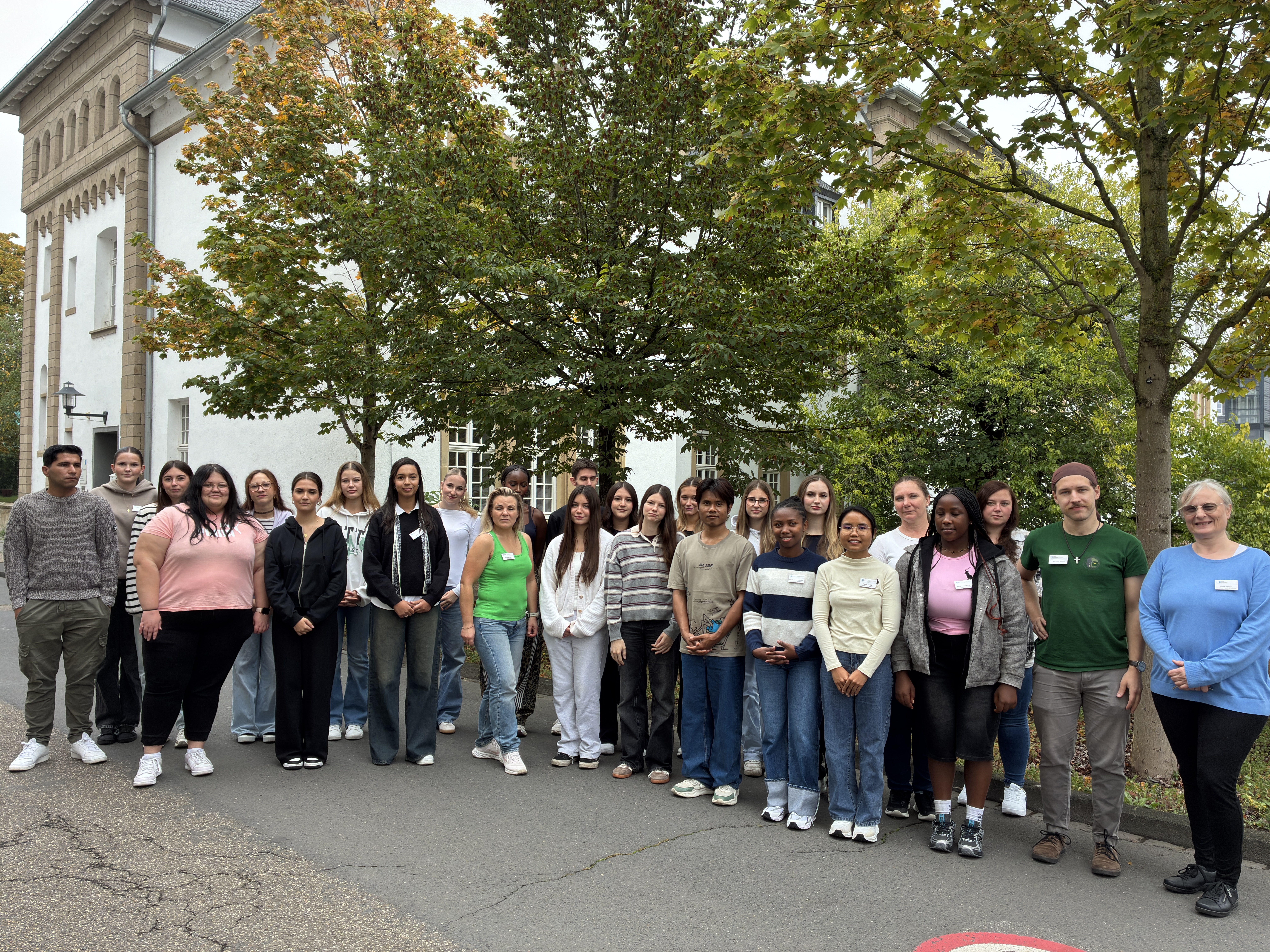 Kurs O26 Gruppe junger Menschen steht zusammen und schaut in die Kamera.
